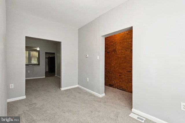 908 Mckean Ave, Baltimore, MD 21217 - empty room featuring carpet flooring, visible vents, baseboards, and brick wall