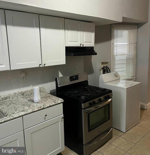 kitchen with under cabinet range hood, gas stove, washer / clothes dryer, light tile patterned flooring, and decorative backsplash