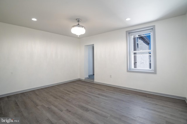 unfurnished room with wood finished floors, baseboards, and recessed lighting