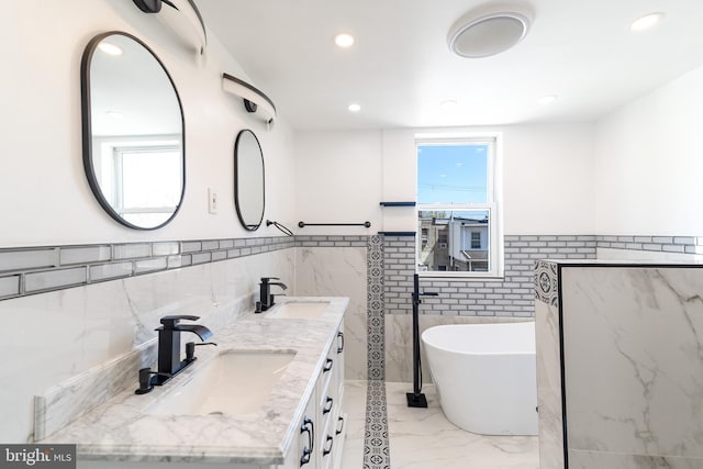 bathroom featuring tile walls, a sink, and a wainscoted wall