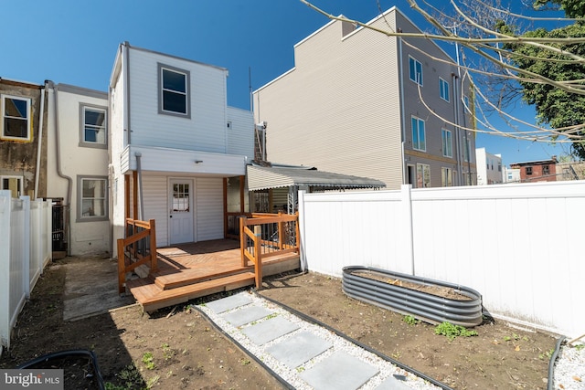 back of house with a fenced backyard and a wooden deck