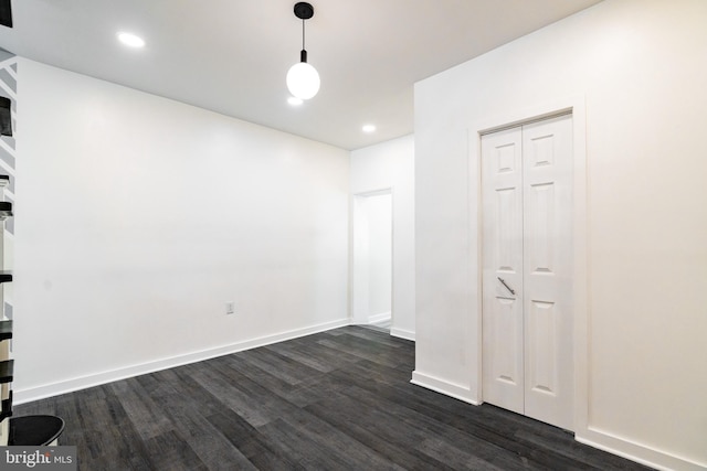 spare room featuring dark wood-style flooring, baseboards, and recessed lighting