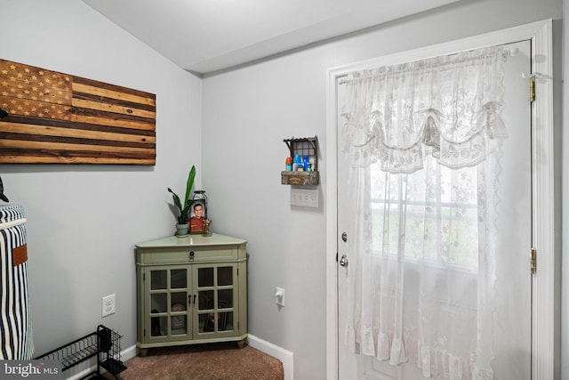 doorway to outside featuring dark carpet and baseboards
