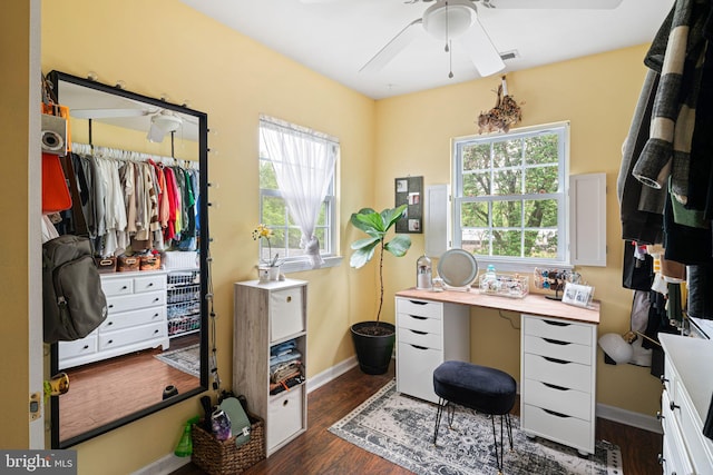 walk in closet with a ceiling fan and dark wood finished floors