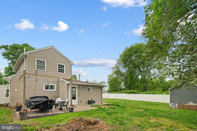 rear view of house with a patio area, an outbuilding, and a storage unit