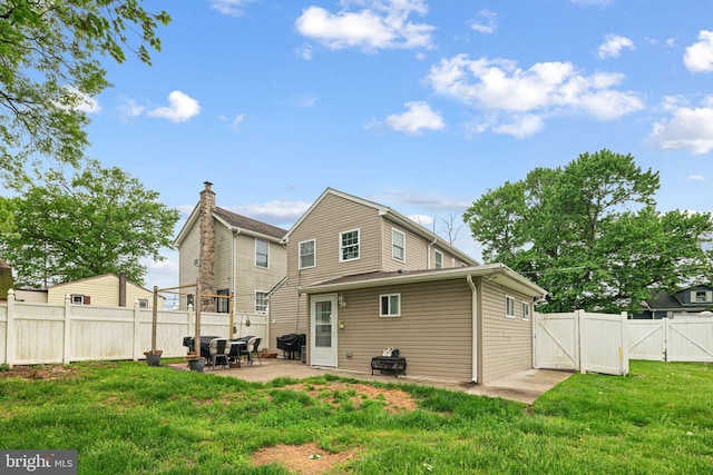 rear view of house with a gate and a patio