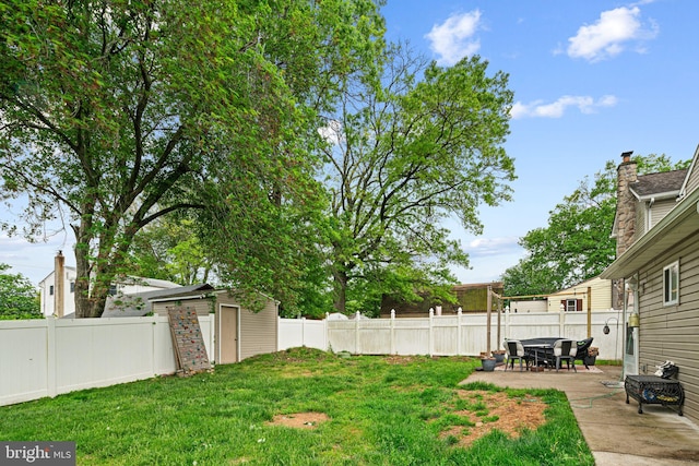 view of yard with a patio, a storage shed, and an outdoor structure