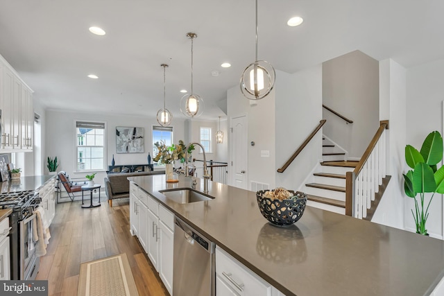 5992 Passend Dr, Frederick, MD 21703 - kitchen featuring appliances with stainless steel finishes, a sink, white cabinetry, light wood finished floors, and recessed lighting