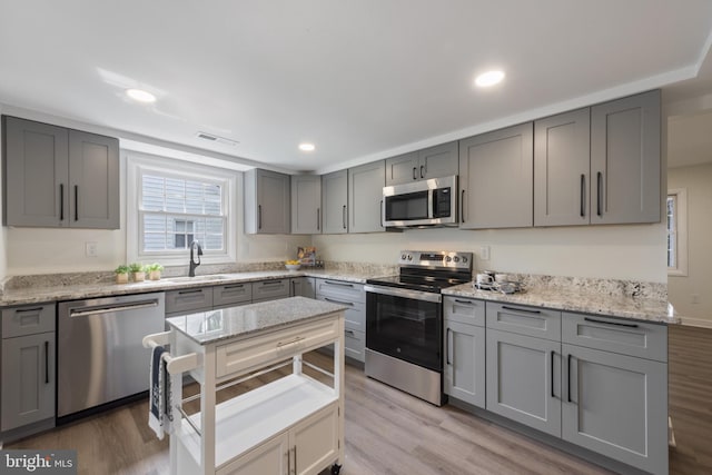 1806 Crofton Pkwy, Crofton, MD 21114 - kitchen featuring stainless steel appliances, gray cabinets, light wood-style flooring, recessed lighting, and light stone countertops