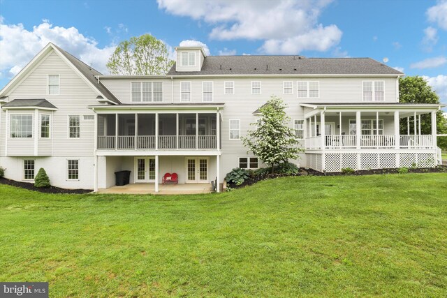 rear view of property with french doors, a sunroom, a patio area, and a yard