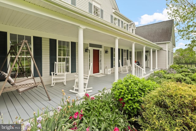 property entrance with covered porch and a shingled roof