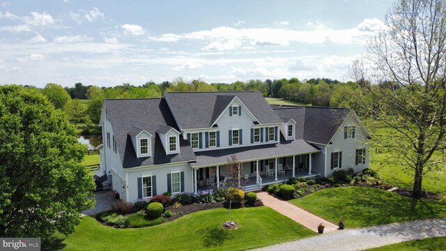 view of front of property featuring covered porch and a front yard