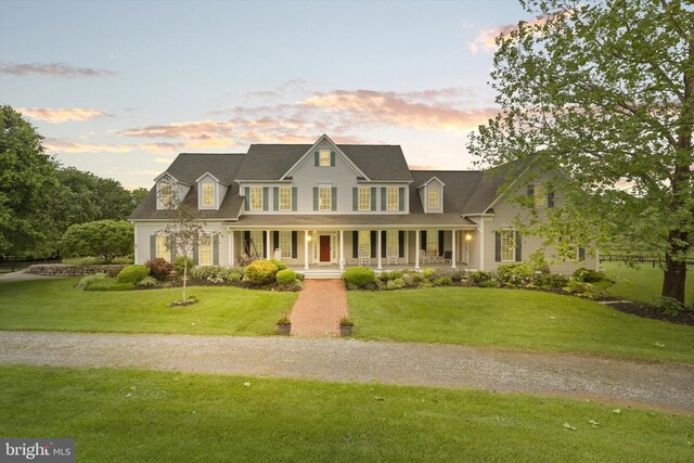 view of front of house with covered porch and a front lawn