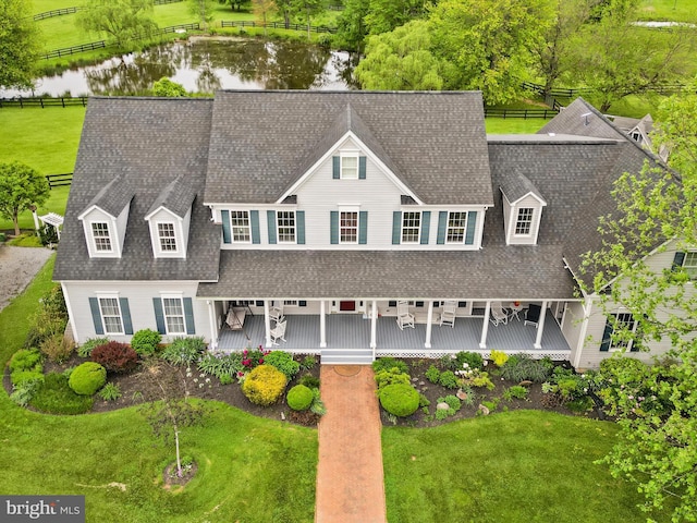 view of front of property featuring a water view and roof with shingles