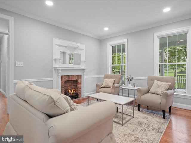 living area with a fireplace, ornamental molding, wood finished floors, recessed lighting, and baseboards