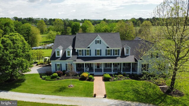 view of front of home with covered porch and a front yard