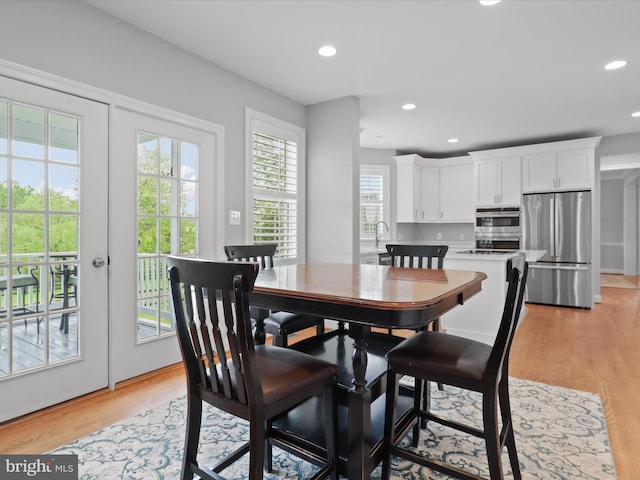 dining space with recessed lighting and light wood-style flooring