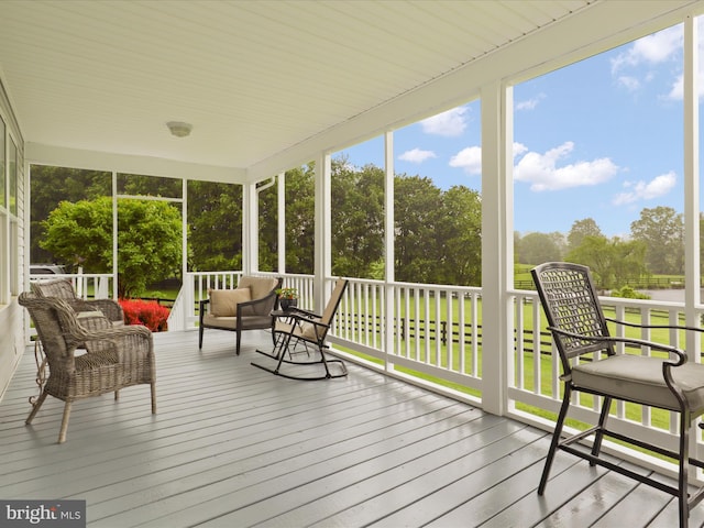 sunroom featuring outdoor lounge area and view of scattered trees