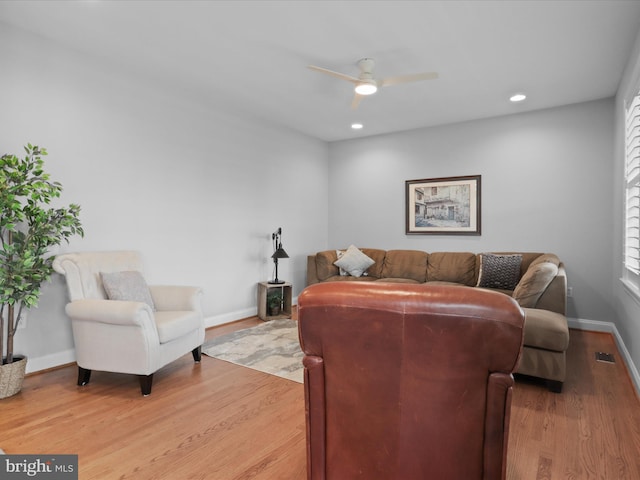 living room featuring a ceiling fan, baseboards, light wood finished floors, and recessed lighting