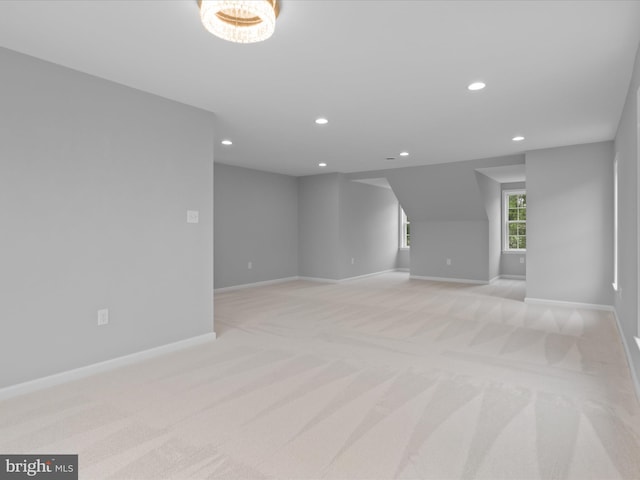 spare room featuring recessed lighting, light carpet, and baseboards