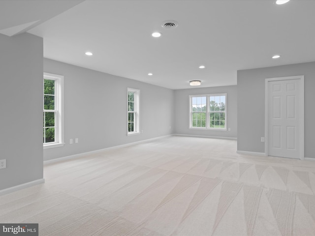 spare room with light carpet, recessed lighting, and baseboards