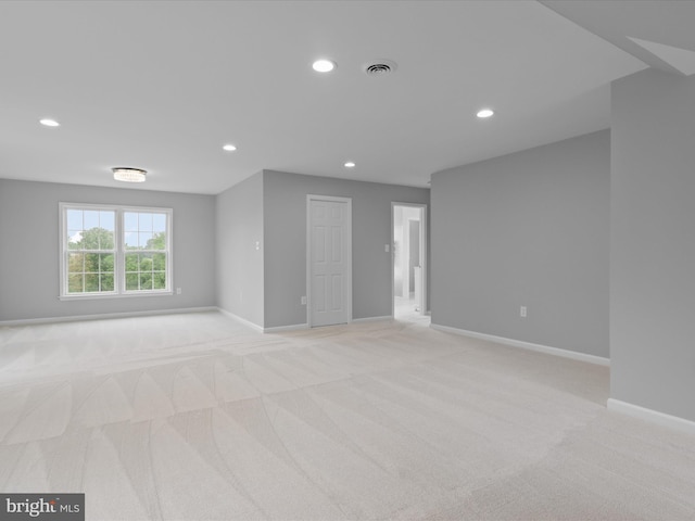 unfurnished room with light colored carpet, recessed lighting, and baseboards