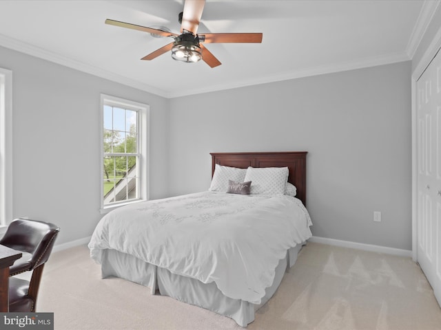 carpeted bedroom with crown molding, baseboards, a closet, and ceiling fan