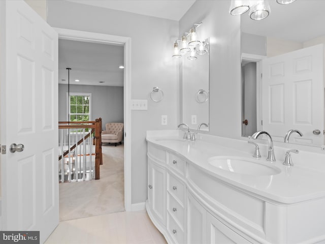 bathroom featuring double vanity, tile patterned flooring, and baseboards