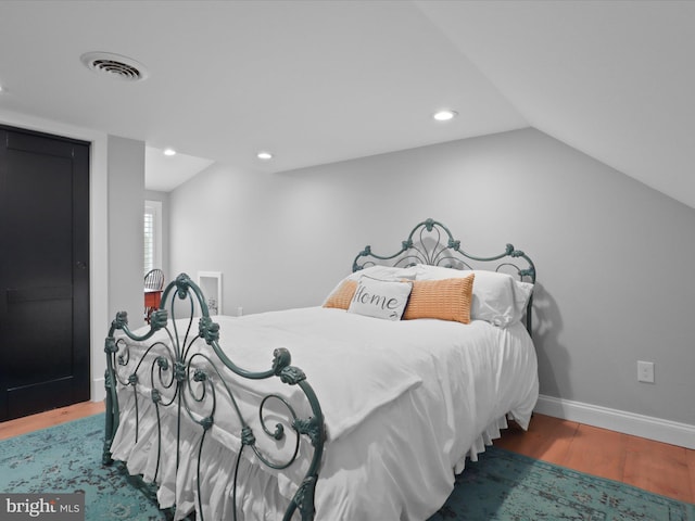 bedroom featuring wood finished floors, recessed lighting, lofted ceiling, and baseboards