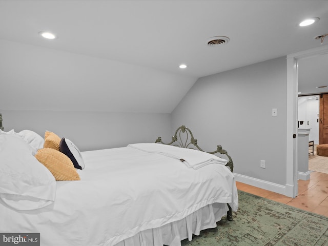 bedroom featuring wood finished floors, recessed lighting, baseboards, and lofted ceiling