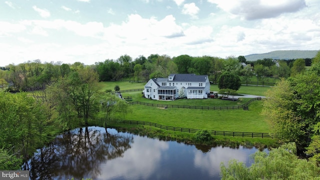 view of rural area featuring a nearby body of water and a forest