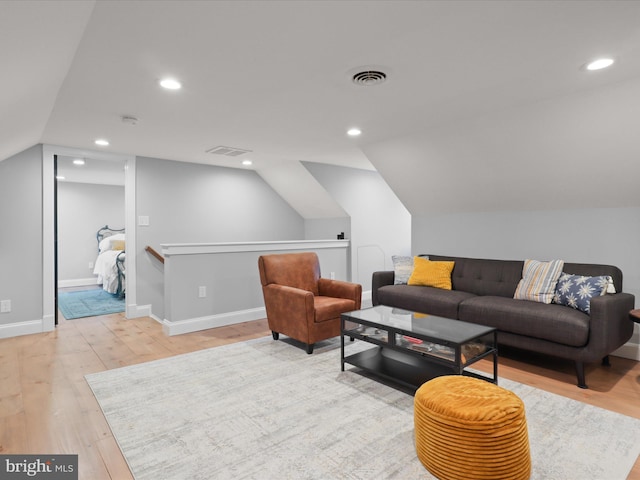 living room featuring lofted ceiling, wood finished floors, recessed lighting, and baseboards