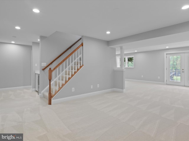 below grade area featuring light carpet, recessed lighting, stairway, and baseboards