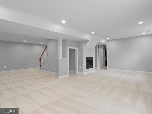 finished basement featuring light colored carpet, recessed lighting, baseboards, a fireplace, and stairway