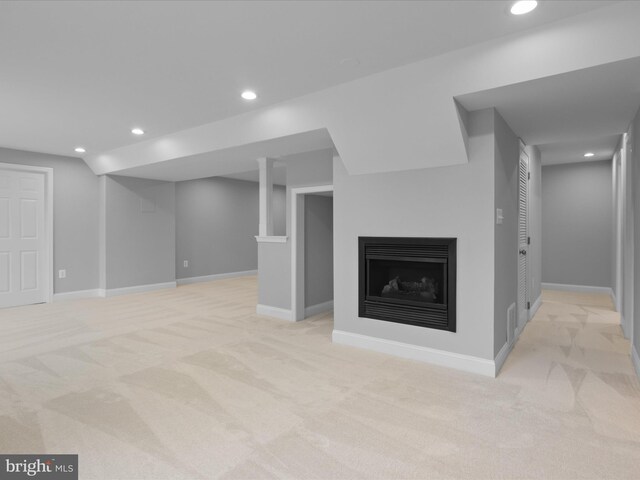unfurnished living room featuring light colored carpet, recessed lighting, a fireplace, and baseboards