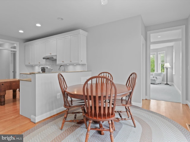 dining space with light wood-type flooring, recessed lighting, and baseboards