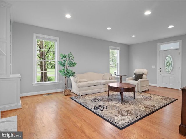 living room with plenty of natural light, recessed lighting, baseboards, and light wood-style flooring