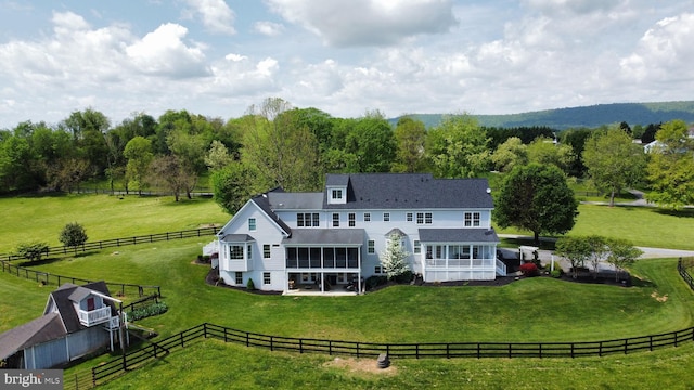 back of house featuring a sunroom, a rural view, and a patio