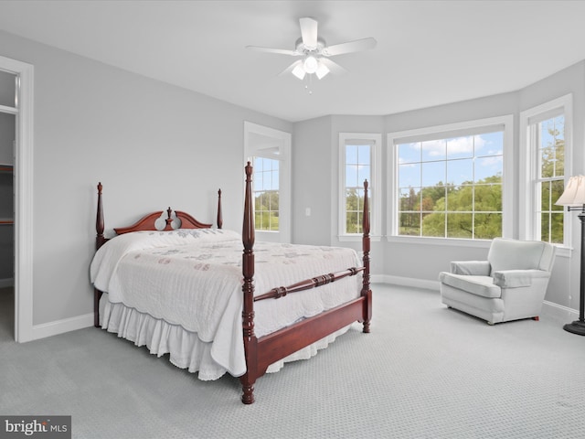 carpeted bedroom featuring baseboards and multiple windows
