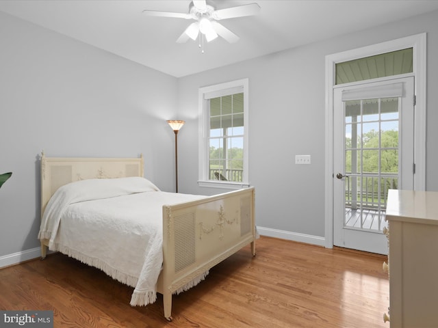 bedroom featuring access to outside, wood finished floors, baseboards, and ceiling fan