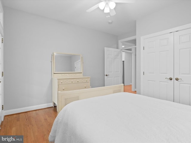 bedroom featuring light wood-type flooring, a closet, baseboards, and ceiling fan