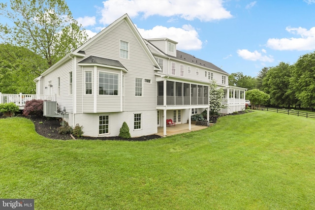 rear view of house featuring a sunroom, a patio area, and central AC