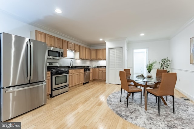 1840 D St NE Unit 1, Washington, DC 20002 - kitchen featuring appliances with stainless steel finishes, crown molding, light wood finished floors, tasteful backsplash, and dark countertops