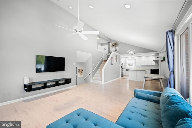 living area with light wood-style flooring, recessed lighting, baseboards, a ceiling fan, and stairs