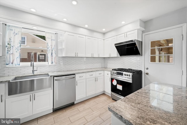 kitchen with stainless steel appliances, extractor fan, a sink, white cabinetry, and decorative backsplash