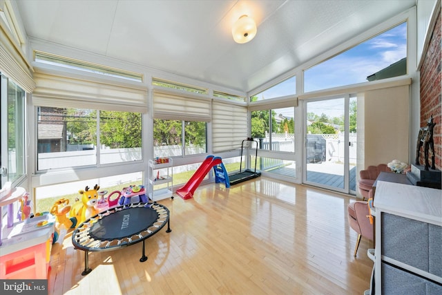 playroom with wood finished floors and vaulted ceiling