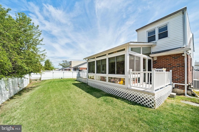back of house with a sunroom, brick siding, and a wooden deck