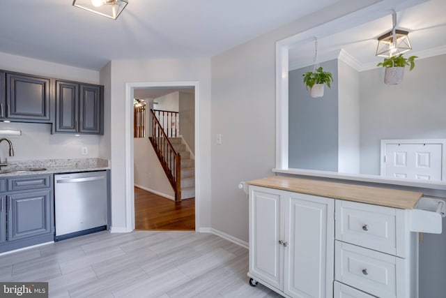 46919 Trumpet Cir, Sterling, VA 20164 - kitchen featuring stainless steel dishwasher, a sink, baseboards, light wood-style flooring, and light stone countertops