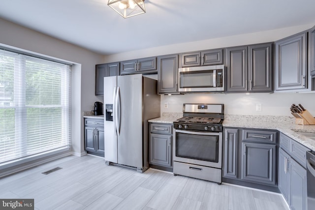 46919 Trumpet Cir, Sterling, VA 20164 - kitchen featuring appliances with stainless steel finishes, light stone counters, gray cabinetry, and a sink