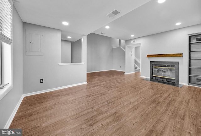 4 Ingham Way, New Hope, PA 18938 - unfurnished living room with wood finished floors, a tiled fireplace, baseboards, recessed lighting, and stairway